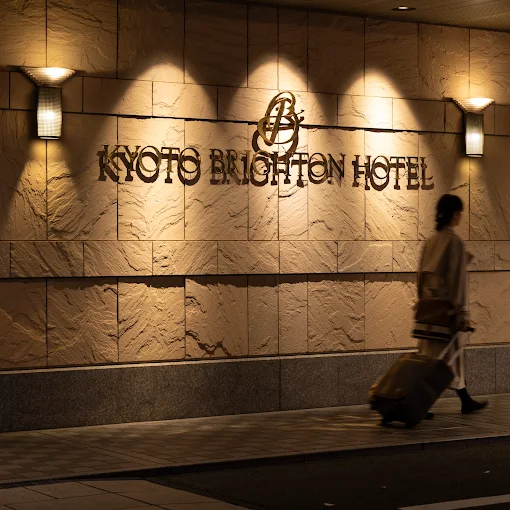 a person walking with luggage in front of a building