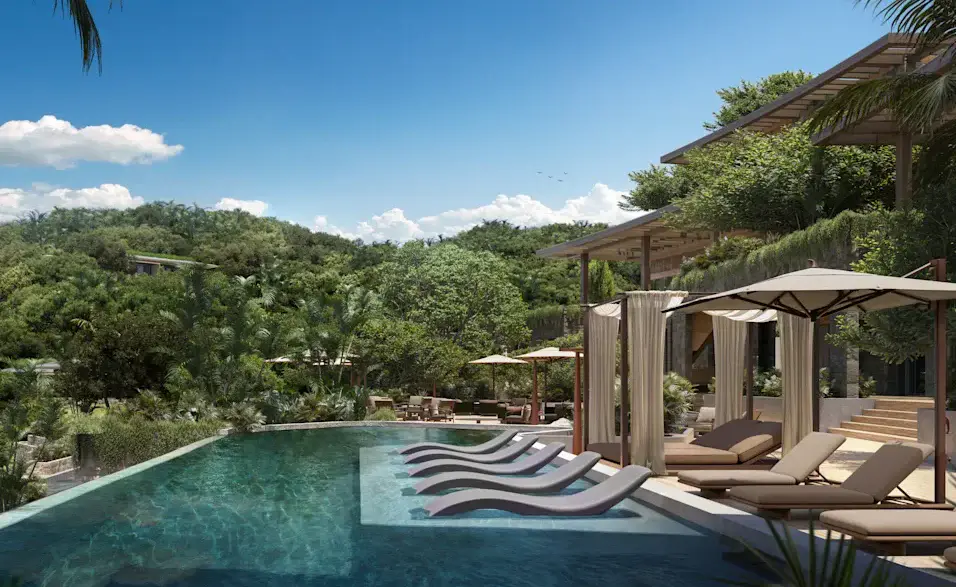 a pool with lounge chairs and trees in the background