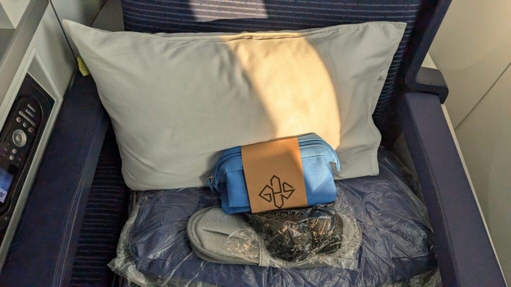 a blue bag and slippers on a white pillow