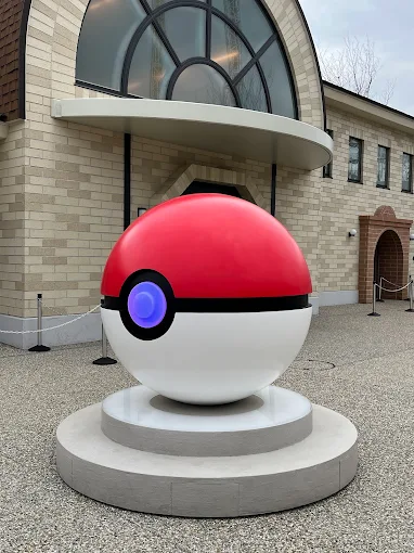 a red and white ball in front of a building