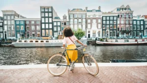 a woman standing on a brick walkway with a bicycle