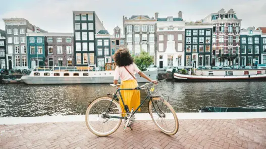 a woman standing on a brick walkway with a bicycle