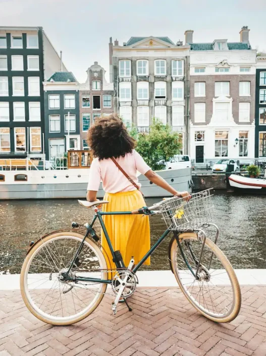 a woman standing on a brick walkway with a bicycle