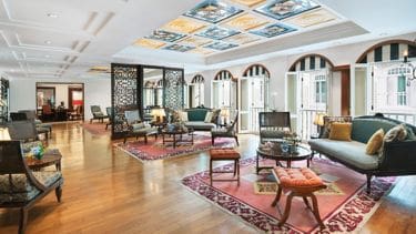 a room with a large area rug and chairs