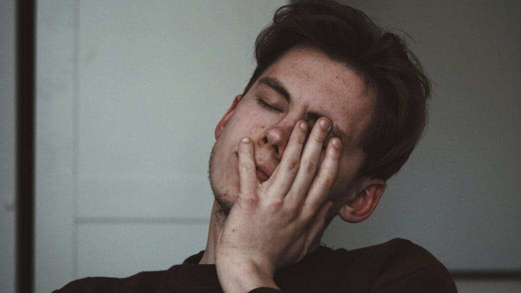 a man with his hand on his face