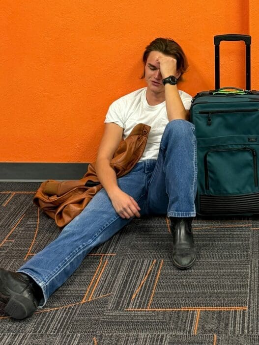 a man sitting on the floor with his hand on his face