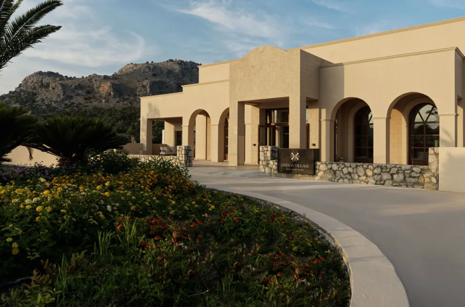 a building with a stone walkway and a hill in the background