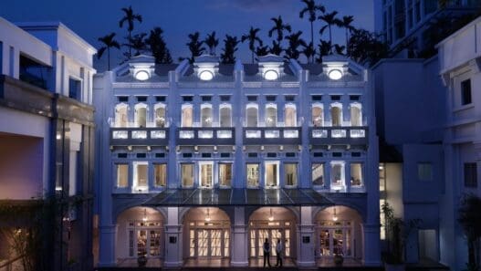 a building with many windows and a couple of people standing in front of it