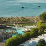 a swimming pool and a beach with a body of water