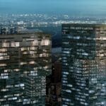 a two tall buildings with lights on them