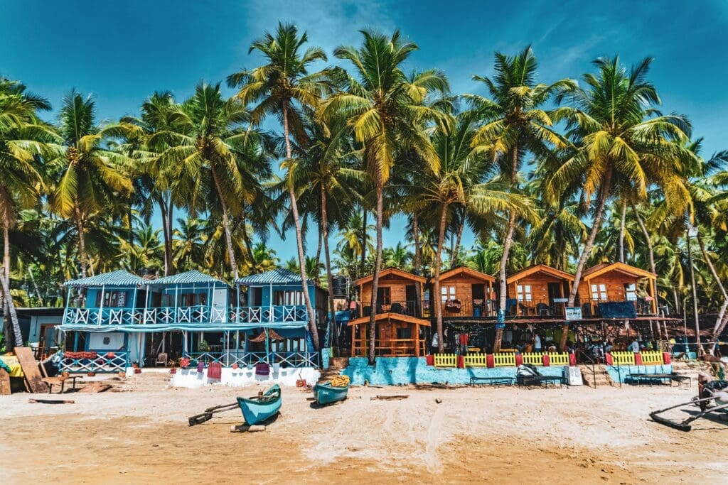 a row of houses on a beach with palm trees