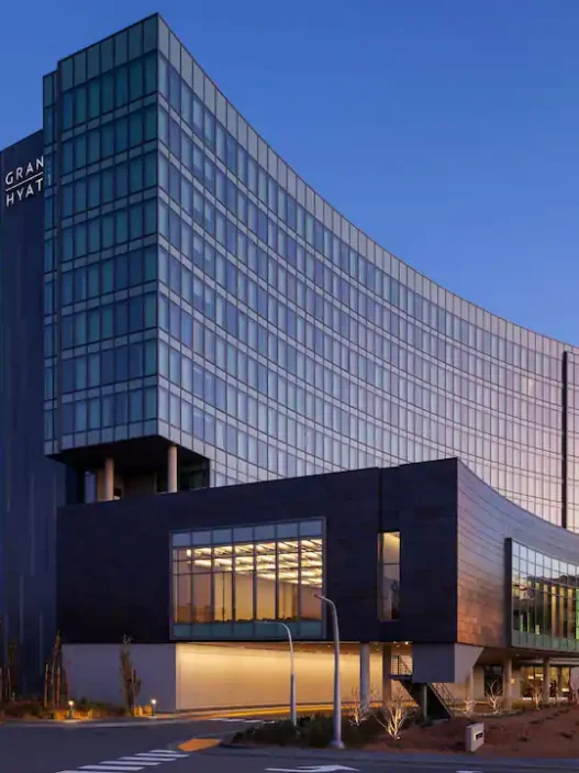 a building with a curved glass wall and a statue
