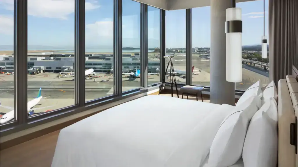 a room with a bed and a window with a view of the airport