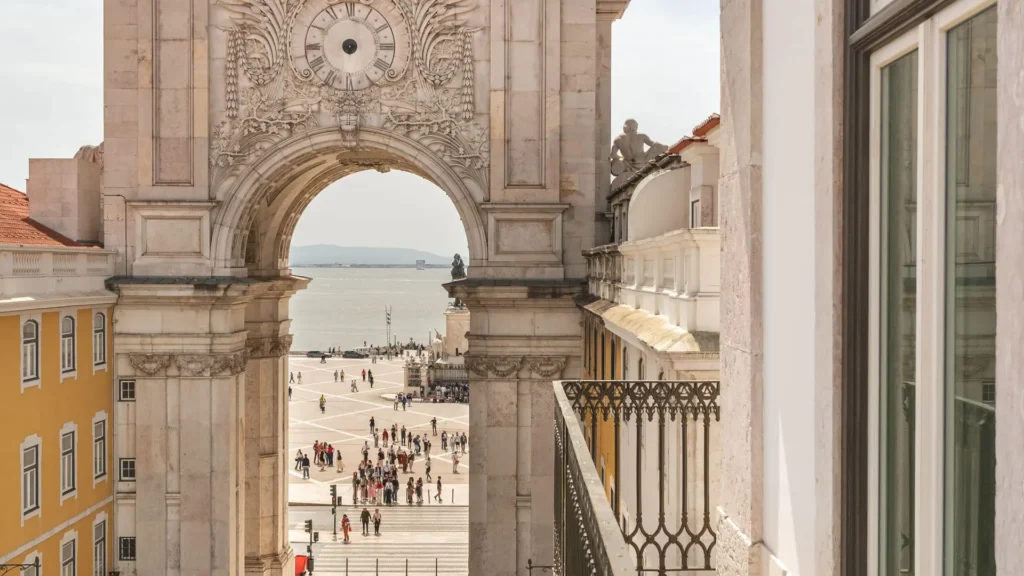 a large stone archway with people walking around