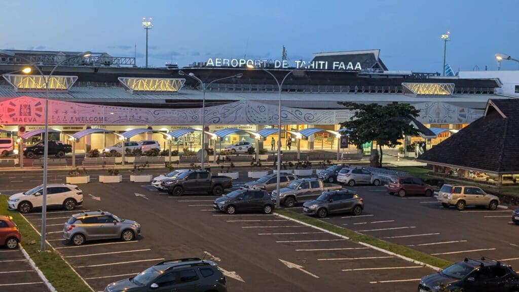 a parking lot with cars and a building with lights