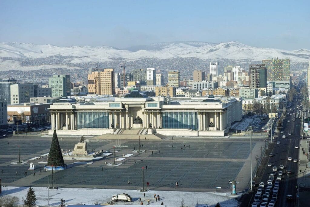 a large white building with a large square and a large christmas tree in front of it