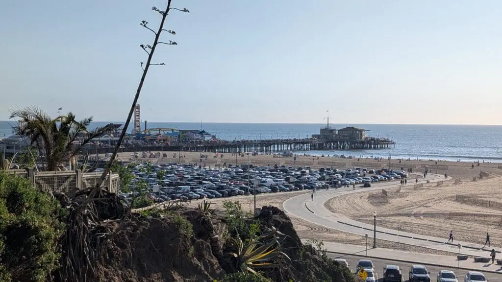 a parking lot with a pier in the background