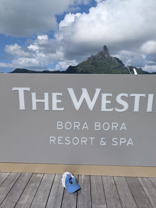 a sign on a dock with a blue hat on it