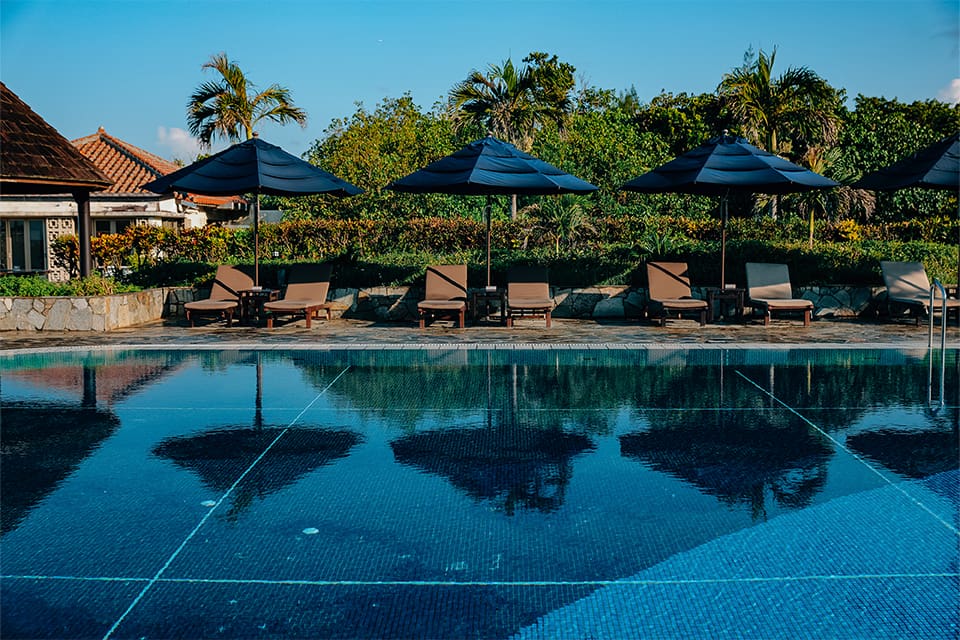 a pool with chairs and umbrellas