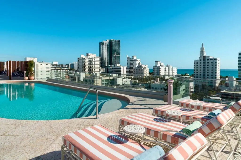 a pool with chairs and a city skyline