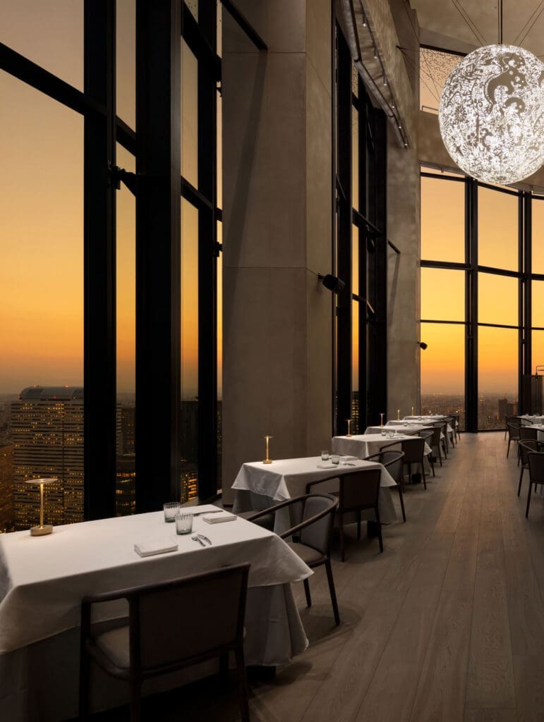 a room with tables and chairs and a large window