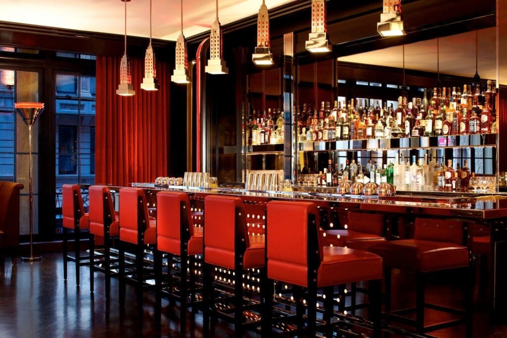 a bar with red chairs and a bar with red chairs