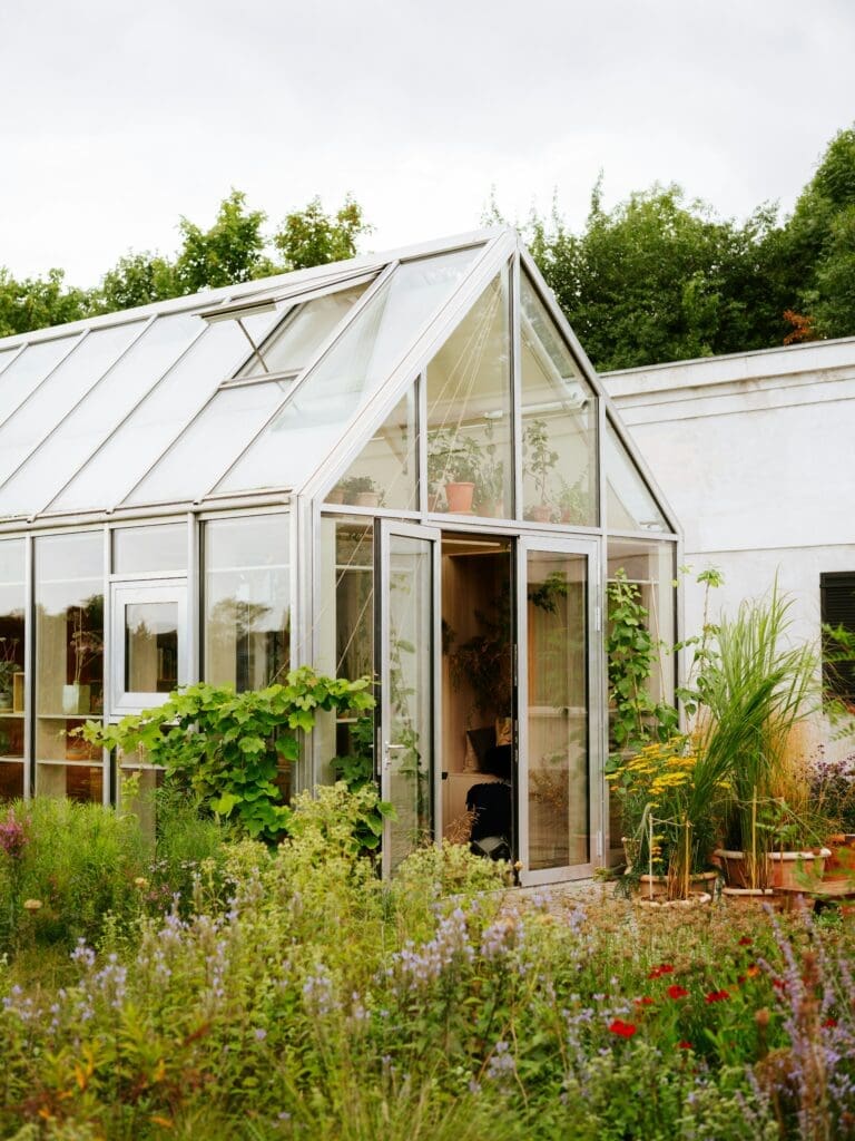 a greenhouse with plants in front of it